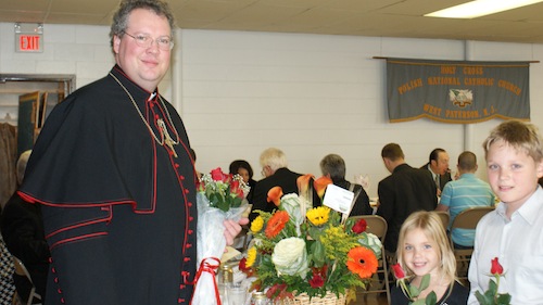 Bishop Anthony Mikovsky received the bouquet of flowers donated by Adoration Society. Flowers were presented by Michael and Natalie Cyman – “Thank you Bishop Anthony for coming to Holy Cross Church and blessing our church rectory,” 